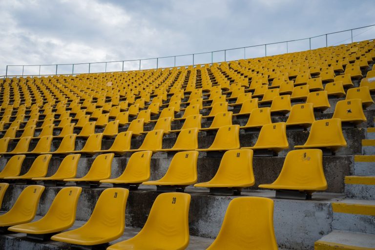 Asientos amarillos vacíos en las gradas de un estadio
