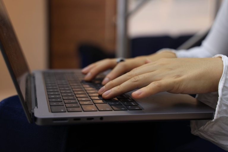 Manos de una persona escribiendo en el teclado de un ordenador portátil