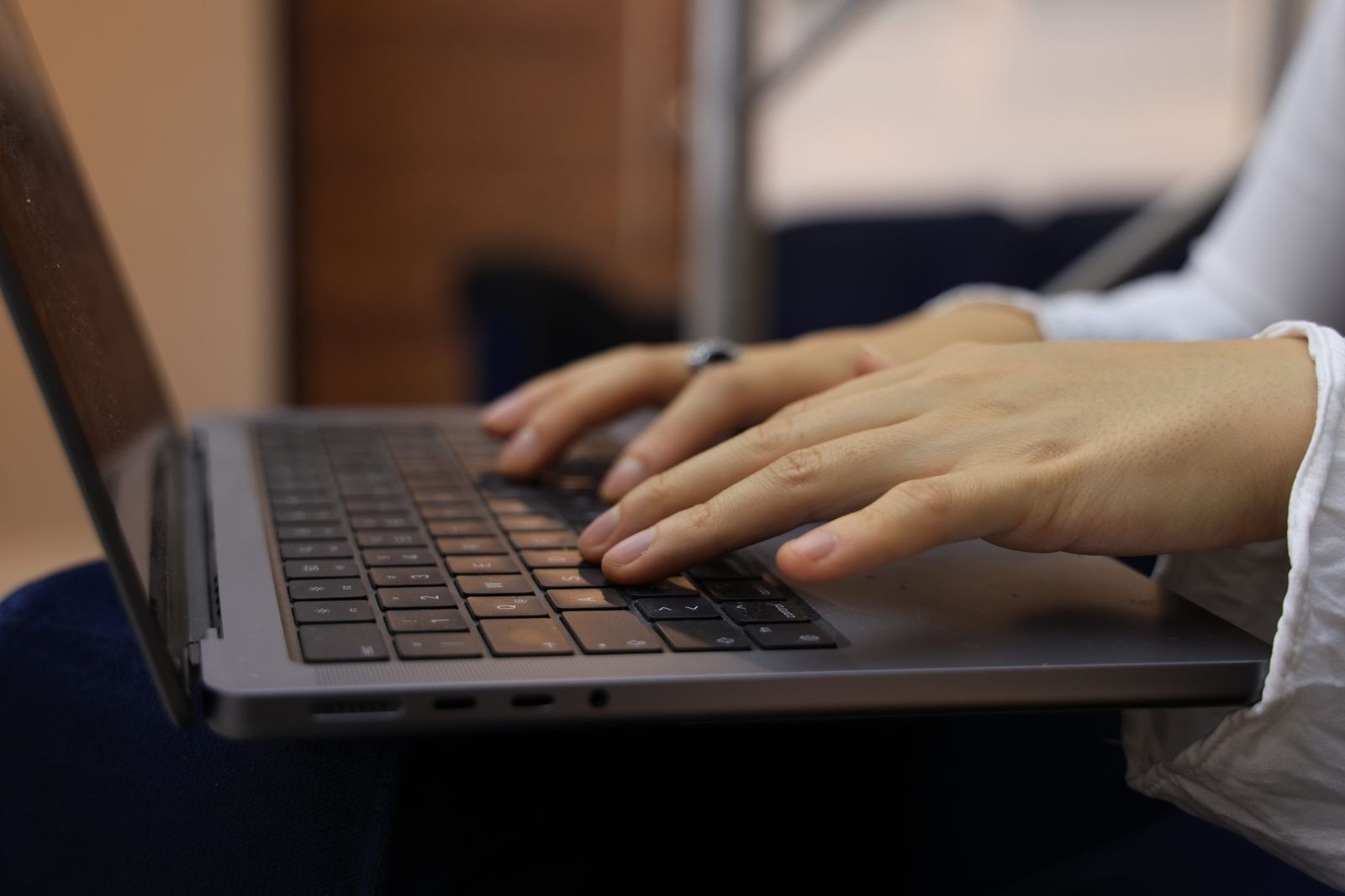 Manos de una persona escribiendo en el teclado de un ordenador portátil