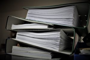 Varios archivadores de anillas apilados y llenos de documentos, en primer plano