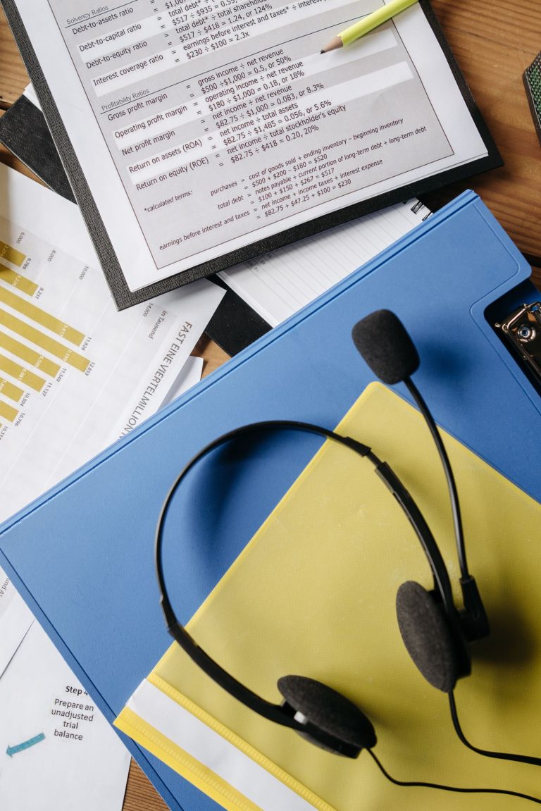 Auriculares y gráficos sobre la mesa de un puesto de atención telefónica