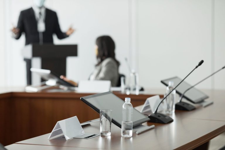 Sala de conferencias con tabletas sobre la mesa, preparada para una jornada profesional